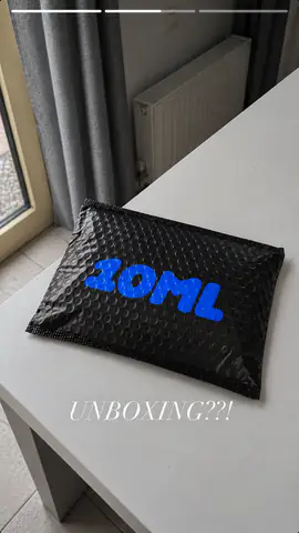 A black 10ML mailer on a table, captioned “Unboxing??!”